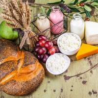 Milk, bread, fruits and dairy products on wooden table