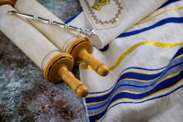 Prayer shawl (tallit) with Torah scroll in a synagogue